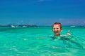 Boy 10 years old bathing in turquoise water tropical sea. Child smiling while showing thumb up. Royalty Free Stock Photo