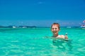 Boy 10 years old bathing in turquoise water tropical sea Child smiling while showing thumb up. Seascape with bright sky and sea Royalty Free Stock Photo