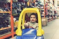 The boy is 4 years old in a construction shop, sitting in a cart. toned