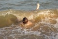 Boy 10 years old enjoys swimming in the coastal waves in the sea