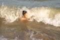 Boy 10 years old enjoys swimming in the coastal waves in the sea