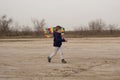 A boy of 4 years old is playing on an empty beach. Flying a kite Royalty Free Stock Photo