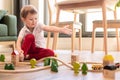 a boy of 4 years old plays a toy train at home on the floor in the living room Royalty Free Stock Photo