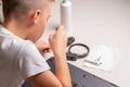 A boy of 10 years old is sorting a laptop for cleaning and maintenance. Selective focus. Screwdrivers, purge cylinder, magnifying Royalty Free Stock Photo