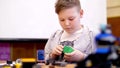 the boy of 11 years, plays in the designer from cubes, plates, circuits, wires. a small inventor creates robots