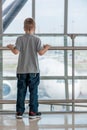 A boy of 7 years standing at the airport watching