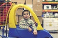 The boy 4 years in a striped jacket is sitting in a children`s typewriter in a construction shop. toned