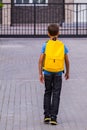 Boy with yellow backpack outdoors. Back view Royalty Free Stock Photo