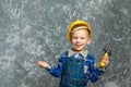 The boy in yellow hard hat holding a hammer Royalty Free Stock Photo