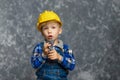 The boy in yellow hard hat holding a pipe wrench in the hands Royalty Free Stock Photo