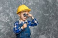 The boy in yellow hard hat holding a pipe wrench in the hands Royalty Free Stock Photo