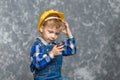 The boy in yellow hard hat holding a pipe wrench in the hands Royalty Free Stock Photo