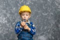 The boy in yellow hard hat holding a pipe wrench in the hands Royalty Free Stock Photo