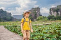 Boy in a yellow on the path among the lotus lake. Mua Cave, Ninh Binh, Vietnam. Vietnam reopens after quarantine