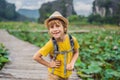 Boy in a yellow on the path among the lotus lake. Mua Cave, Ninh Binh, Vietnam. Vietnam reopens after quarantine