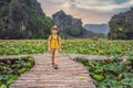 Boy in a yellow on the path among the lotus lake. Mua Cave, Ninh Binh, Vietnam. Vietnam reopens after quarantine