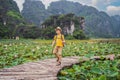 Boy in a yellow on the path among the lotus lake. Mua Cave, Ninh Binh, Vietnam. Vietnam reopens after quarantine Royalty Free Stock Photo