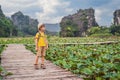 Boy in a yellow on the path among the lotus lake. Mua Cave, Ninh Binh, Vietnam. Vietnam reopens after quarantine