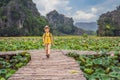 Boy in a yellow on the path among the lotus lake. Mua Cave, Ninh Binh, Vietnam. Vietnam reopens after quarantine Royalty Free Stock Photo