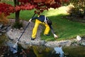 Boy working in the garden, cleaning the pond Royalty Free Stock Photo