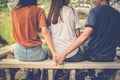 Boyfriend and another woman grab hands from behind together with Royalty Free Stock Photo