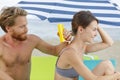 boyfriend applying sunscreen to girlfriends back