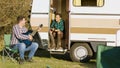 Boyfriend in front of the retro camper van singing on guitar