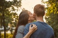 Girl kissing boy in cheek in the park, concept of teen love Royalty Free Stock Photo