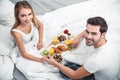 Boyfriend and girlfriend having breakfast in the bed