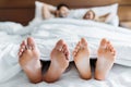 boyfriend and girlfriend lying in bed with feet