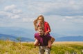 Boyfriend giving woman piggyback on traver. Man carrying woman on back in an summer nature.