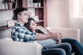 Cheerful international couple sitting on the couch