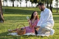 Boyfriend uncork the bottle of champagne on picnic. Man preparing romantic date for beautiful girlfriend outdoors