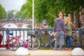 Boyfriends observe the canals of Amsterdam from a bridge