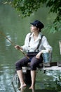 Boyish looking girl fishing outdoors Royalty Free Stock Photo