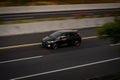 Black Honda Jazz or known as Fit GE8 speeding on trans Java Highway at afternoon blurry in motion