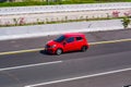 Red honda brio driving fast on trans jawa highway Royalty Free Stock Photo