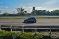 Grey honda brio driving fast on trans jawa highway Royalty Free Stock Photo