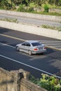 Silver BMW 318i E36 driving fast on trans jawa highway
