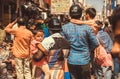 Boys in arms of parents in noisy crowd of the asian street