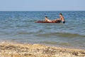 Boys bathe in the sea on an air mattress close to the shore Royalty Free Stock Photo