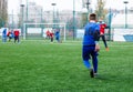 Boys in blue red sportswear plays football on field, dribbles ball. Young soccer players with ball on green grass. Training Royalty Free Stock Photo