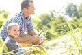 Boys bonding day. Young father sitting beside a lake with his son and fishing. Royalty Free Stock Photo