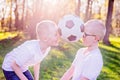 Boys brothers playing with ball on green grass in park. Royalty Free Stock Photo