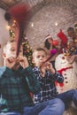Boys celebrating Christmas with family, blowing party whistles
