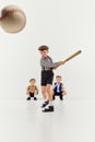 Boys, children in classical retro clothes playing baseball over grey studio background. Hitting. Competition. Concept of