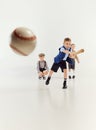Boys, children in classical retro clothes playing baseball over grey studio background. Hitting. Competition. Concept of