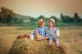 Boys in cowboy hats sitting on a haystack Royalty Free Stock Photo