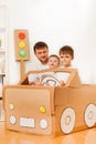 Boys driving dad in toy car made of cardboard box Royalty Free Stock Photo