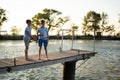 boys is fishing at sunset on the lake jetty with a fishing rod. Summer leisure Royalty Free Stock Photo